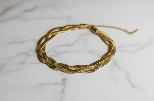 Gold braided necklace on a marble surface