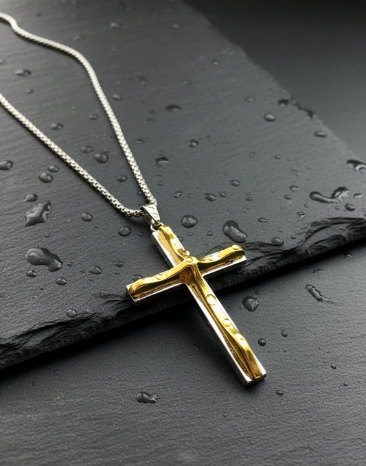 Gold cross pendant on a chain against a dark textured background